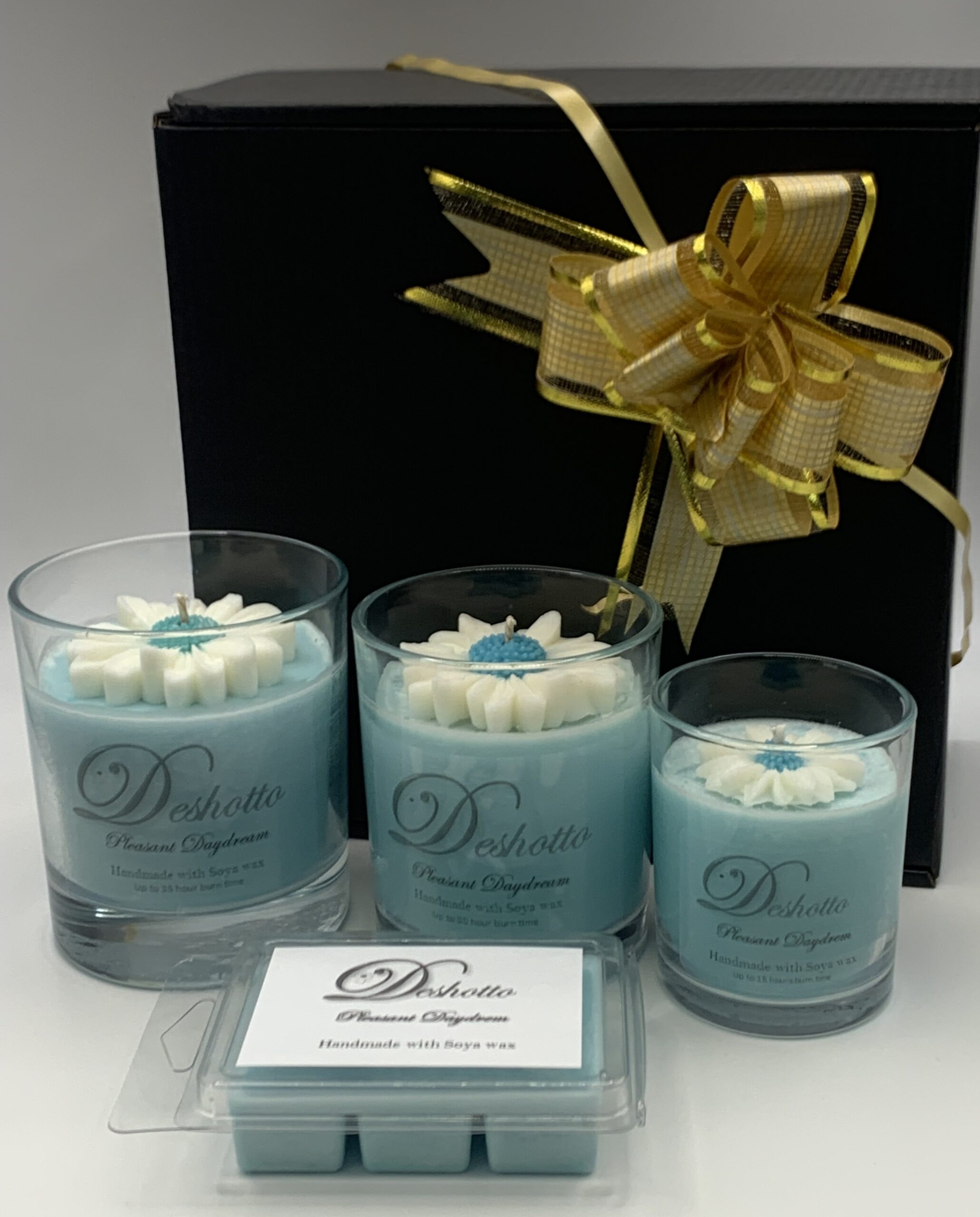 Hands gently cradle a lit candle in a glass holder.